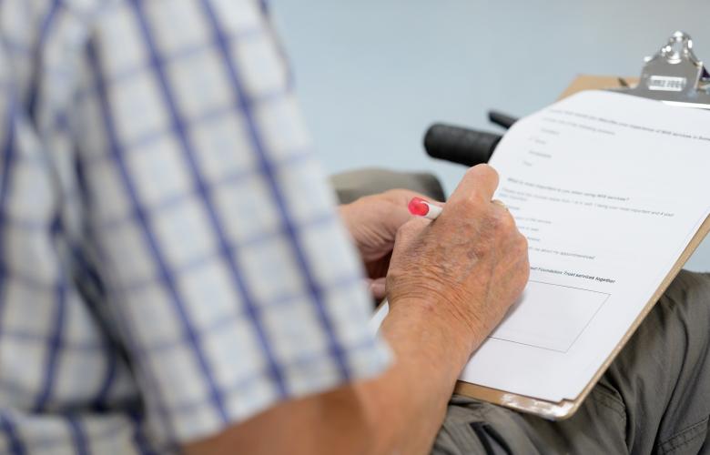 Man's hand completing a survey
